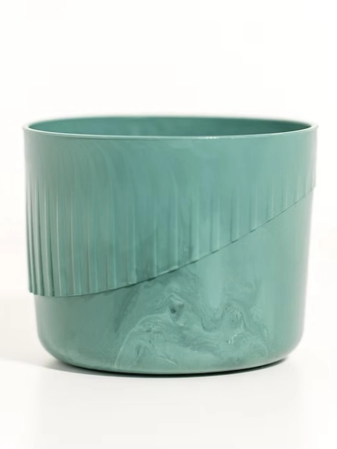 Ocean Plastic Plant Pot Small, a green recycled plant pot sitting on a white surface against a plain backdrop. 