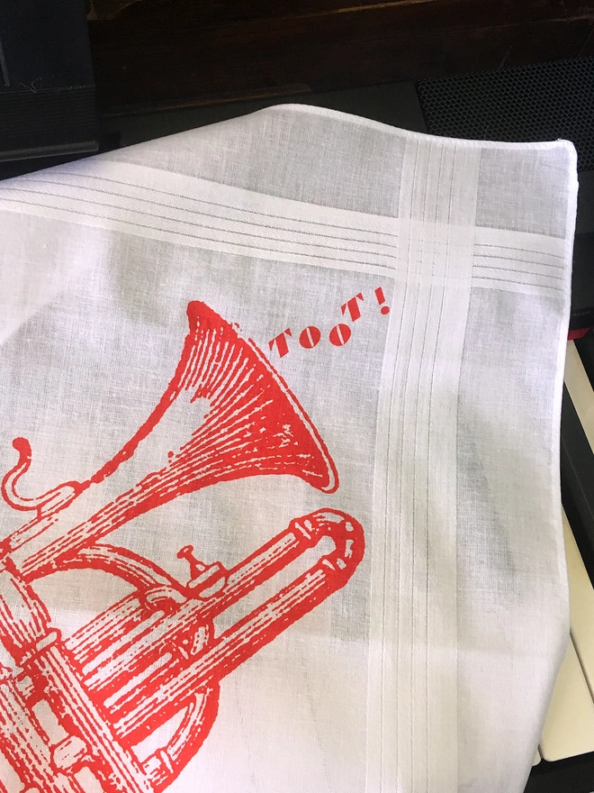 detail of a Mr.PS tooting trumpet hankie laid on a piano