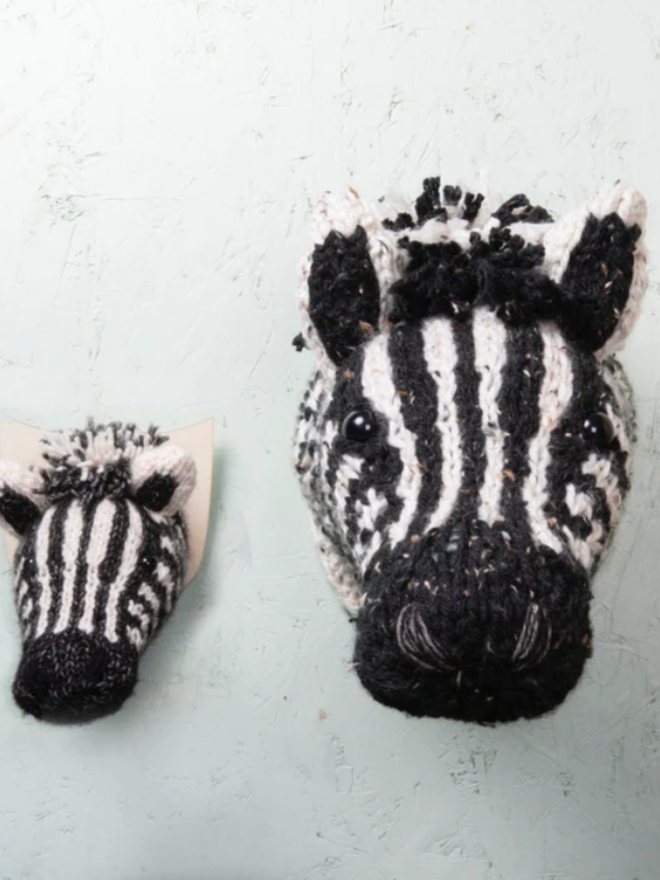 Zebra Head Knitting Kit. A mini and giant zebra head next to each other, completed and mounted.