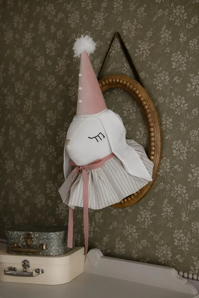 Rabbit Head Wall Mount, a cotton rabbit head wall decoration in a child's bedroom accompanied by other bedroom accessories. 
