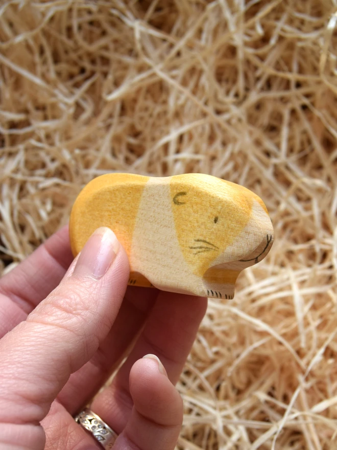 tan and white wooden toy guinea pig