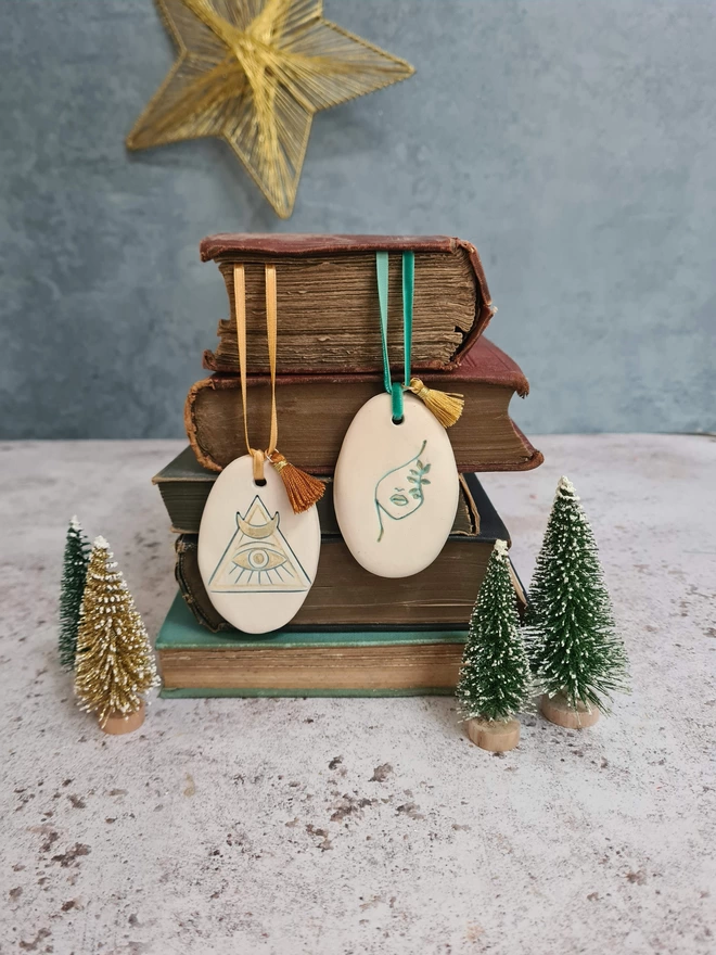 ceramic bookmark charms, christmas decorations, ornaments, ceramic clay, gift, hanging decoration, velvet ribbon with tassel, book lover, homeware, Jenny Hopps Pottery, Stocking filler, photographed with old books and mini christmas trees, charms with womens faces