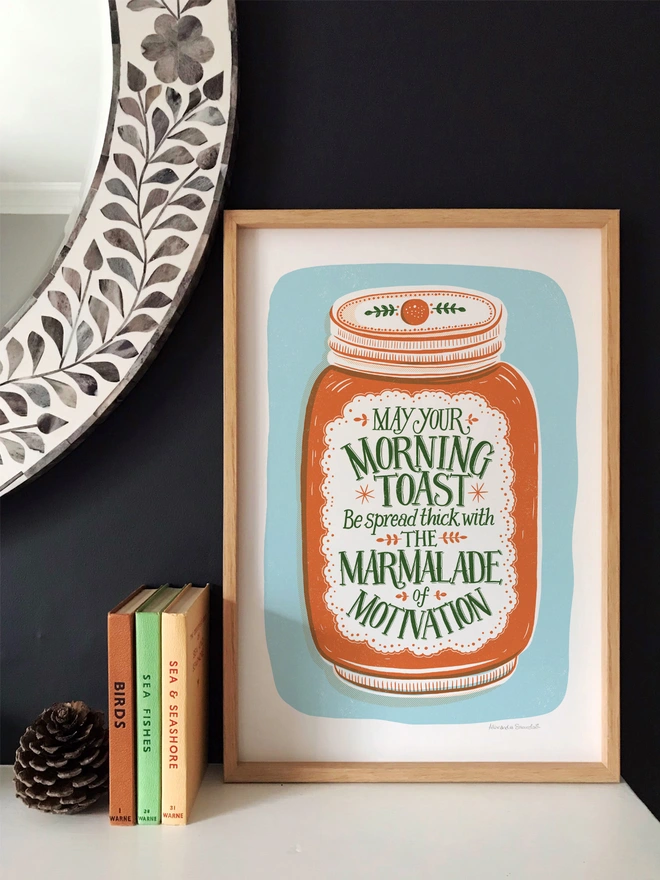 marmalade motivation print in wood frame with books