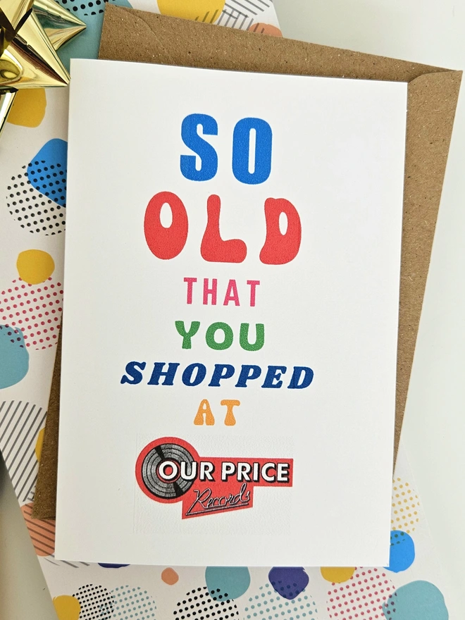 A photograph of the front of a humorous A6 greeting card illustrated using brightly coloured text and the retro shop logo. The text says so old you shopped at OurPrice.