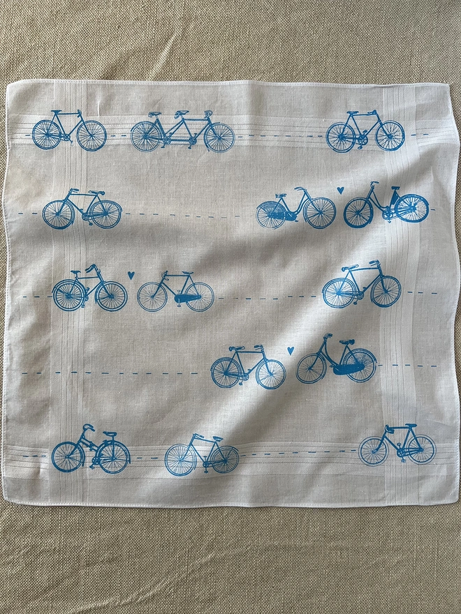 A Mr.PS white cotton handkerchief printed with a pattern of vintage bicycles with little hearts in sky blue