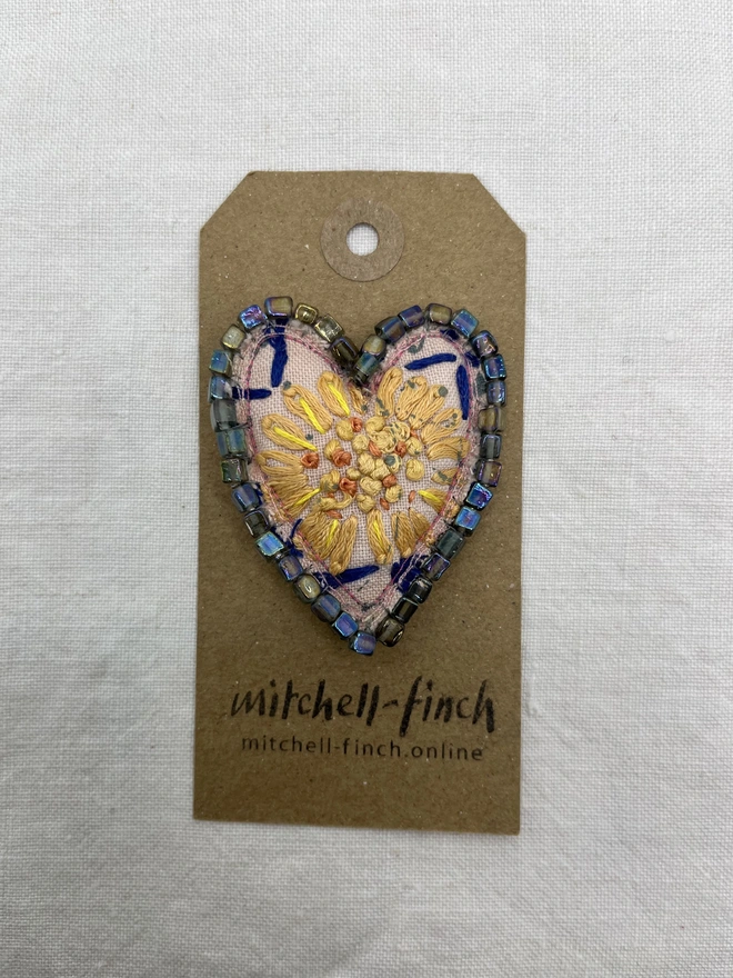 pink and yellow brooch on label