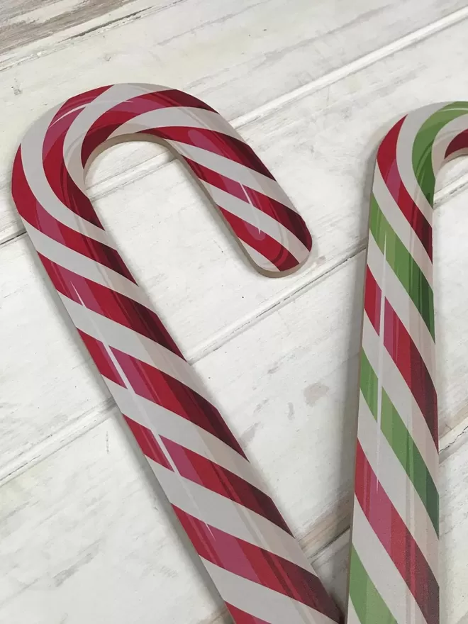 Candy Canes in red and green on a wooden floor.