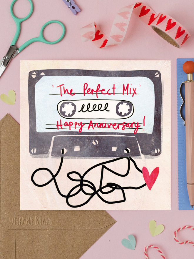 'perfect mix' illustrated anniversary card. card photographed on table with assorted crafting items.