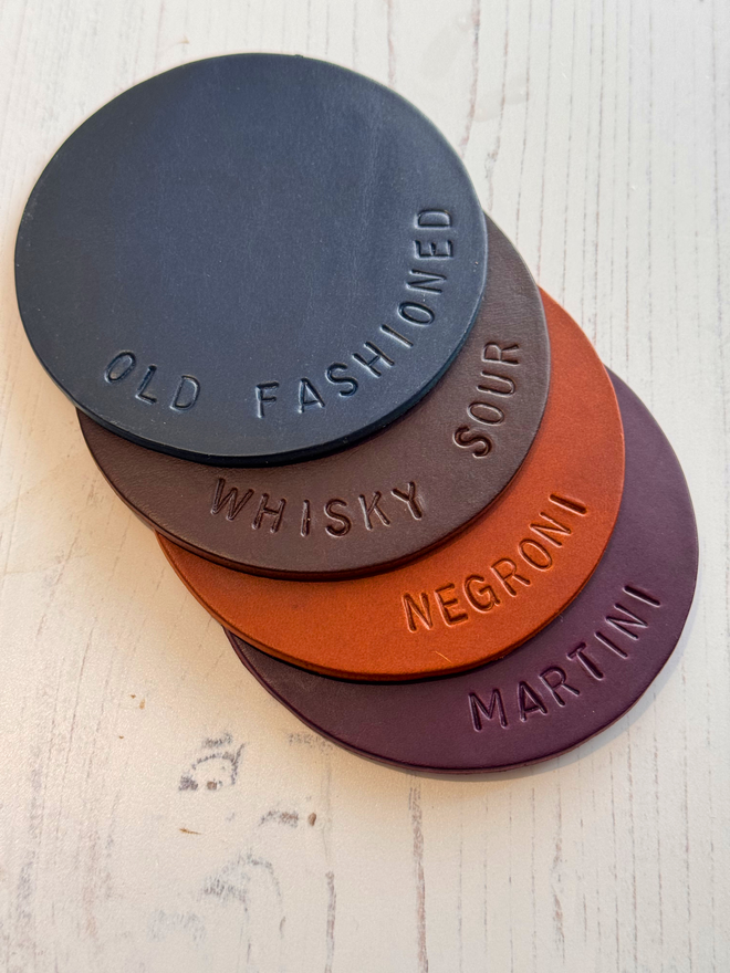 navy, brown, tan and purple set of leather coasters.
