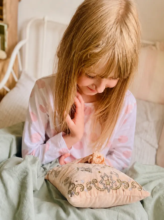 Little Girl looking at Tooth Fairy Pillow Keepsake 