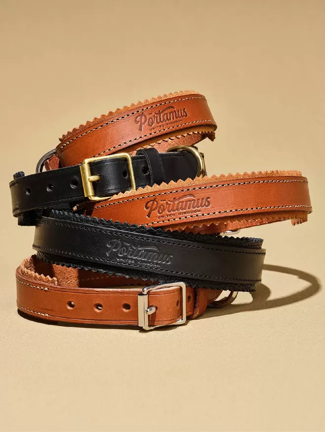 A stack of 4 brown and black leather dog collars.