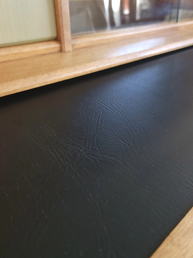 Close up of black vinyl lined pull out shelf on upcycled  vintage mid-century sideboard.