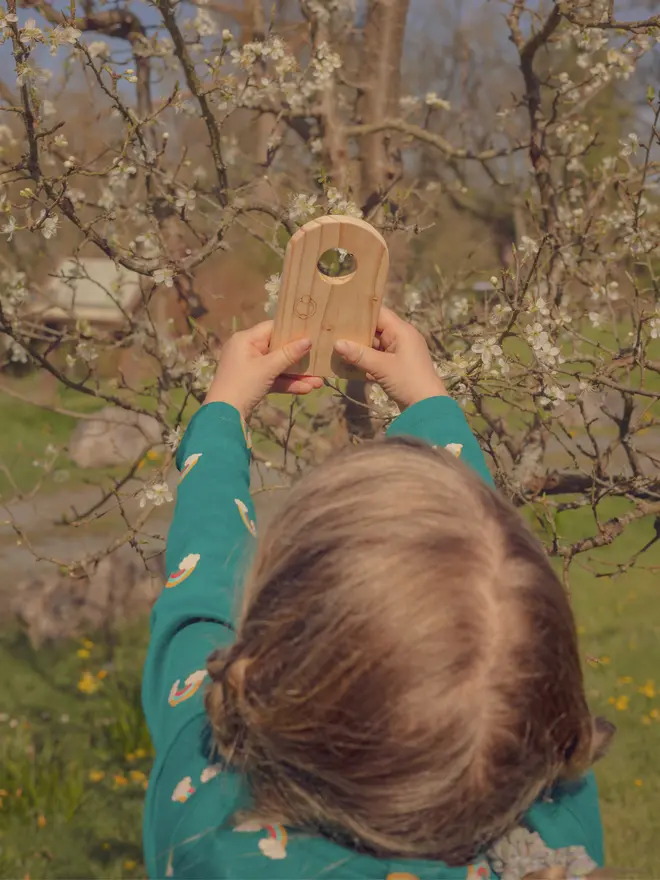 child playing with wooden fairy door