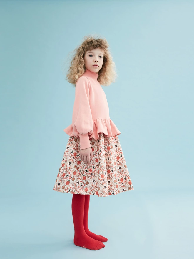 Cotton brushed back sweat to bodice and a cotton sateen dress in our own developed print to skirt. Featuring rib to the neck and deep cuffs, balloon sleeves and a fully gathered peplum. 