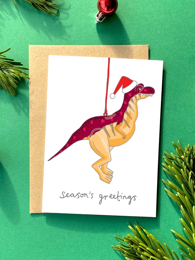 Festive Christmas card featuring kitsch dinosaur decoration 