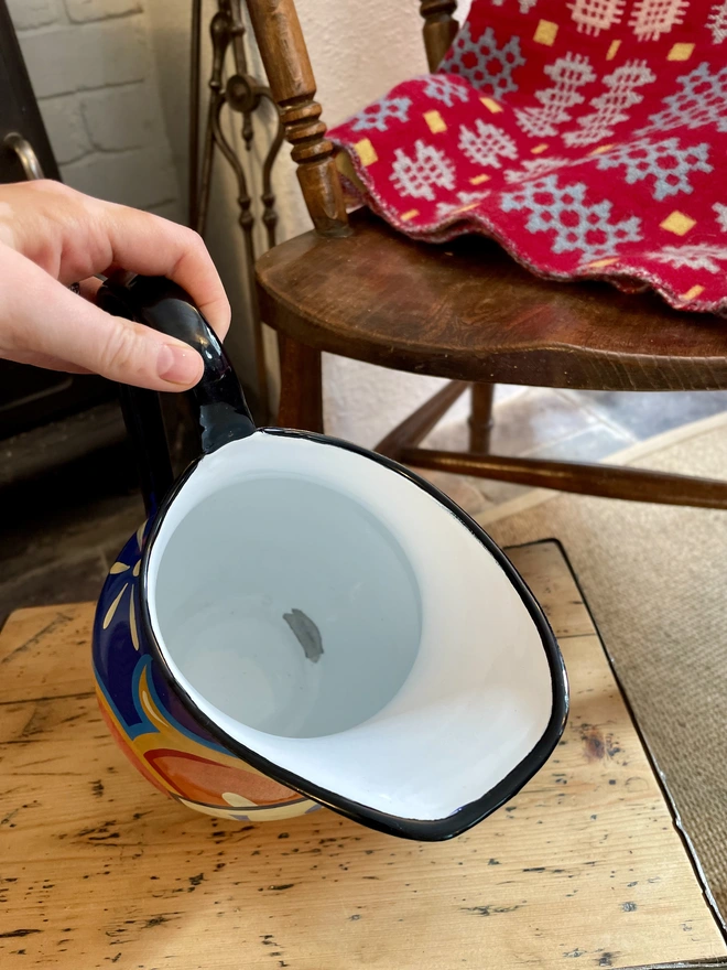 Inside of blue enamel jug. Shows some wear to the enamel but overall in good condition.
