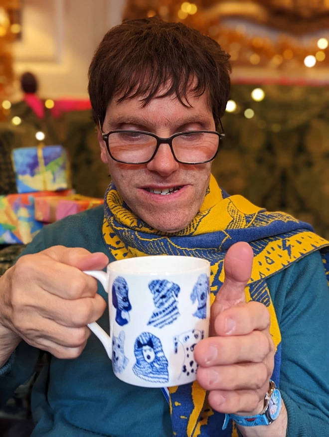Happy artist holding blue dogs charity fine bone china dog gift mug featuring blue dog illustrations