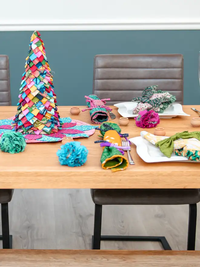 A table with colourful Christmas crackers and a table top tree