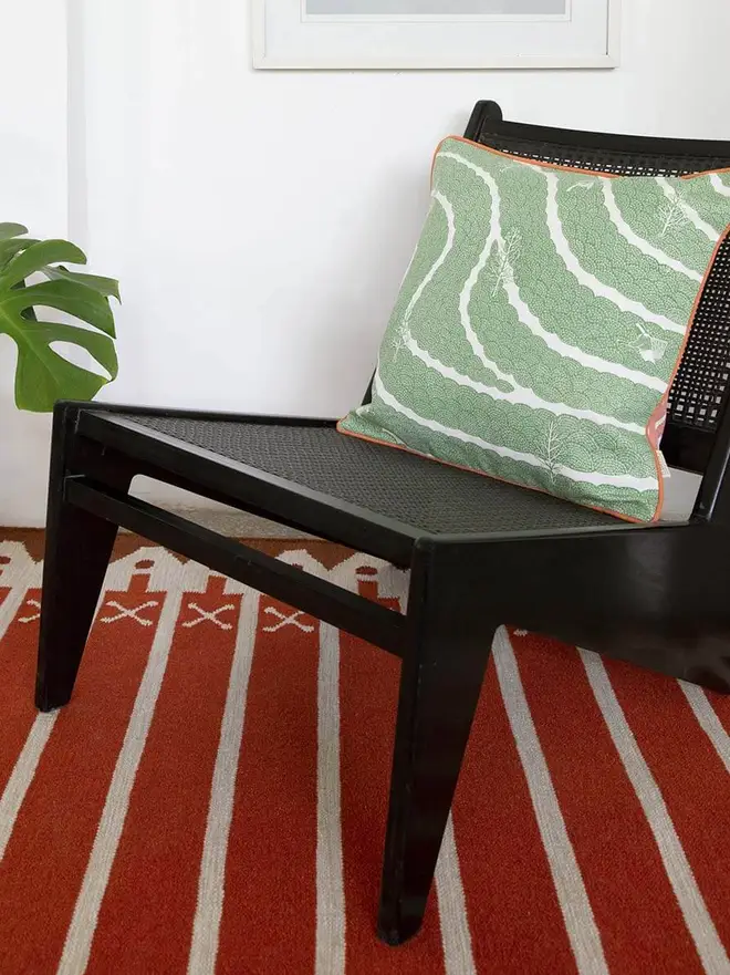 Darjeeling Flatweave Rug, a colourful rug in a living room. It is accompanied by other colourful furniture. 