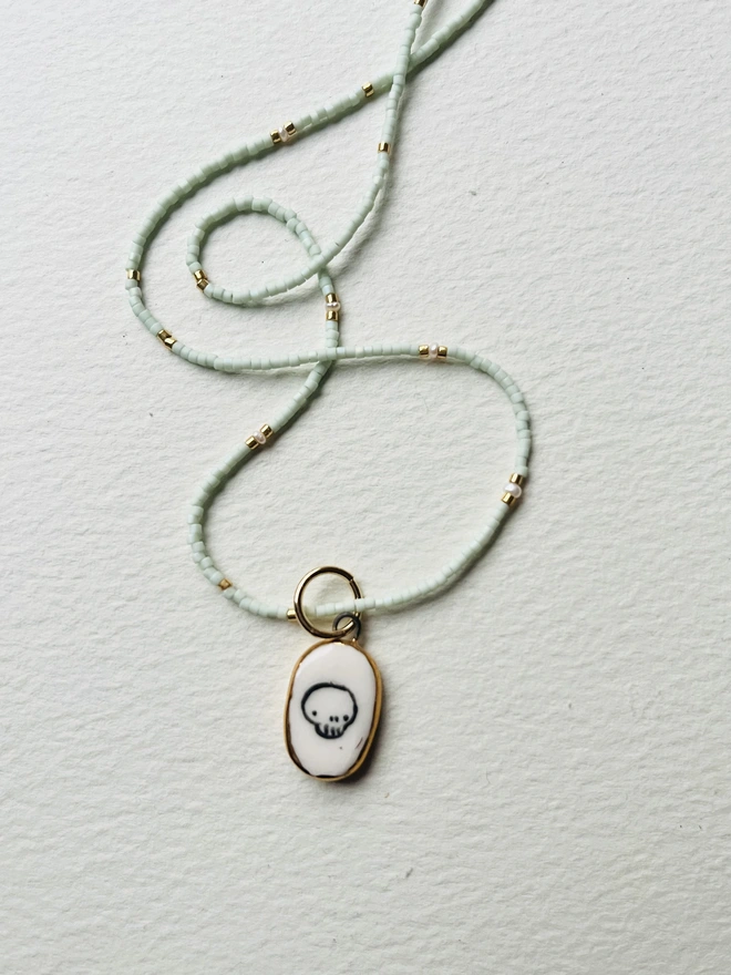 Miyuki bead necklace with light green beads and seed pearls and skull pendant