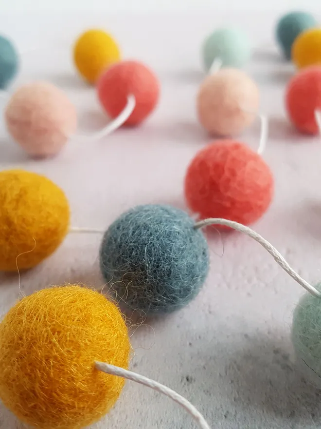 A pastel rainbow pom pom garland.
