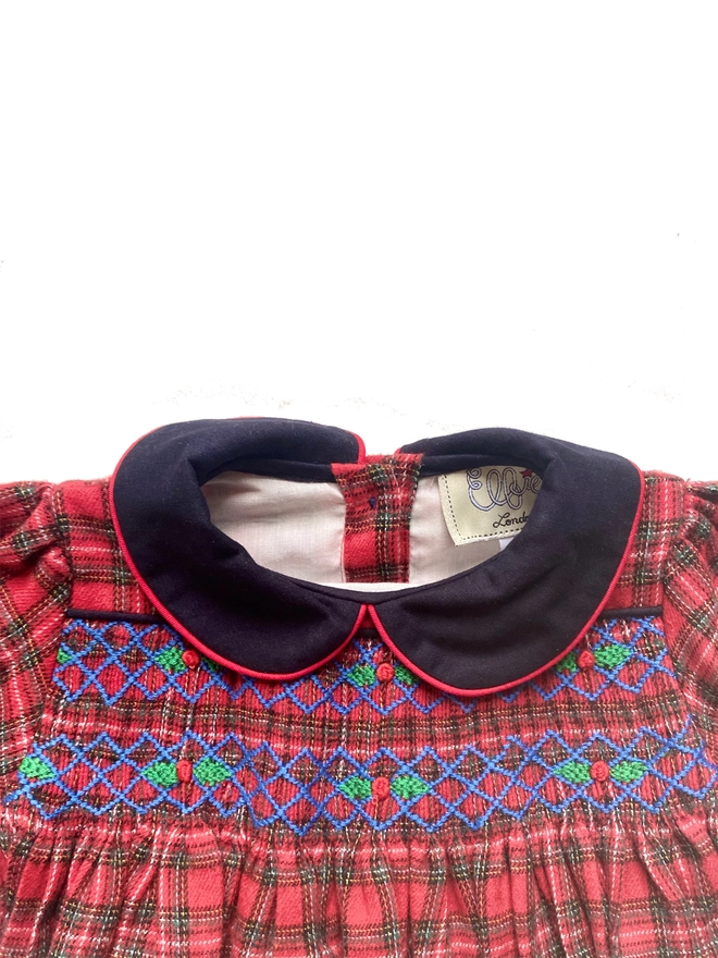 Detail of the hand smocking of a red and navy tartan romper
