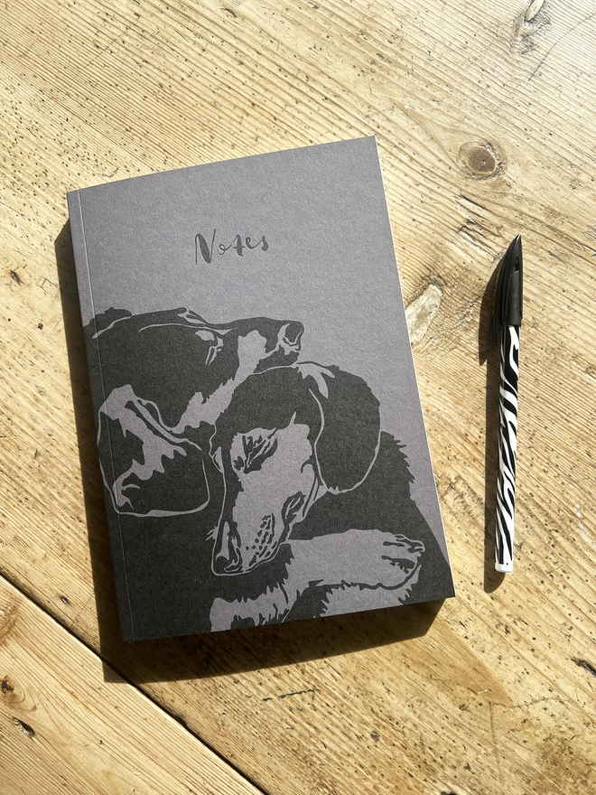 Front of the notebook showing two Dachshunds cuddling with the word notes printed above them. 