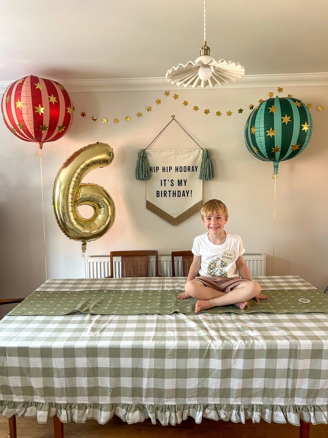 Boy's birthday with red and green round balloons and fabric birthday banner saying Hip Hip Hooray It's My Birthday