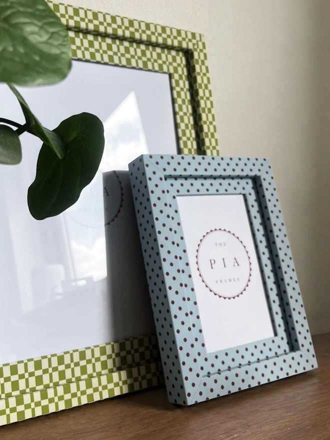 Blue & Burgundy Pembroke Dot Frame, a colourful dotted frame sitting on a wooden surface. It is joined by another frame. 