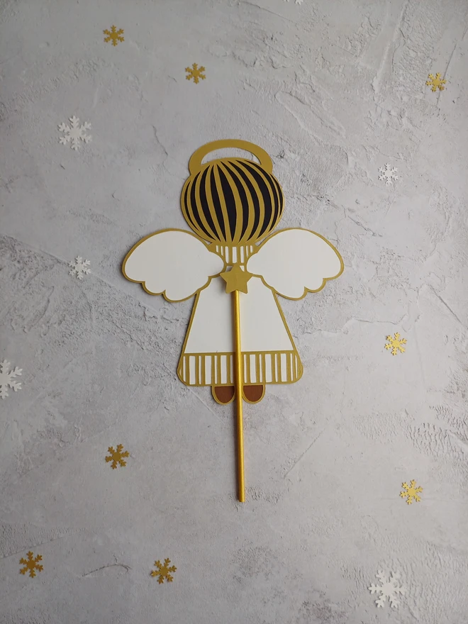 Back view of Angel Tree Topper, Black and Gold hair visible, Gold paper stick topped with gold star sits between angels wings