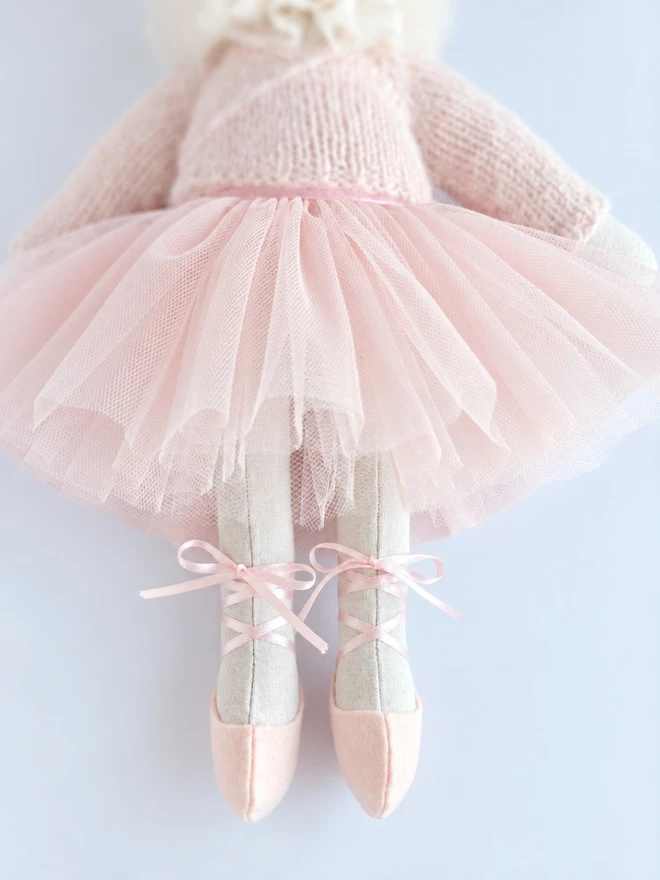 Close-up of ballerina bunny wearing a pale pink tulle tutu and ribbon-laced ballet shoes.