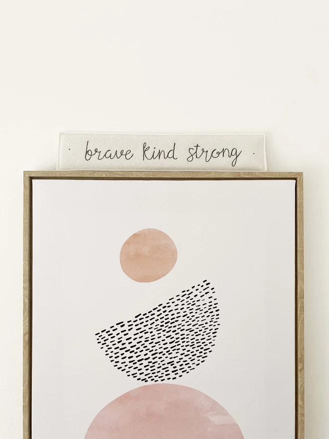 Brave Kind Strong Felt Embroidered Sign on top of picture
