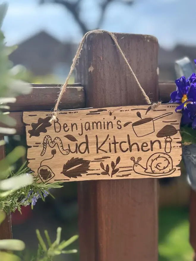 wooden sign reading 'benjamin's mud kitchen'