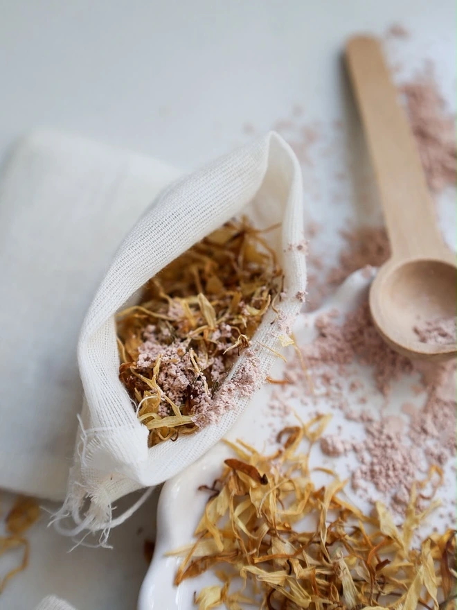 Natural, dried chamomile flowers and bamboo mixing spoon to create bath tea potions. 