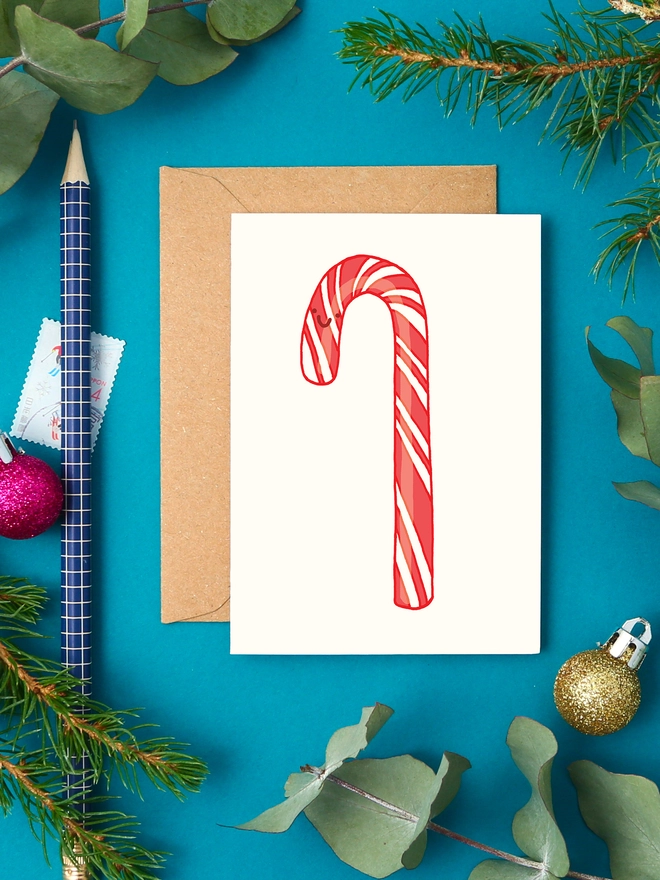 Cute mini christmas card showing a red and white striped candy cane with a happy face