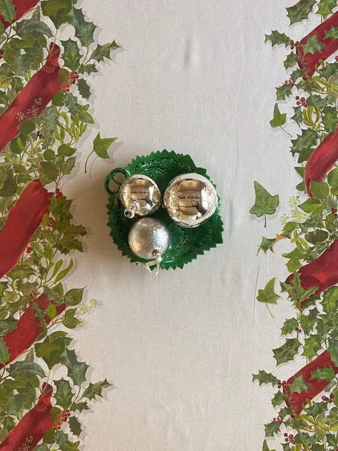 christmas double garland tablecloth. a white table cloth with two painted christmas garlands on a table.
