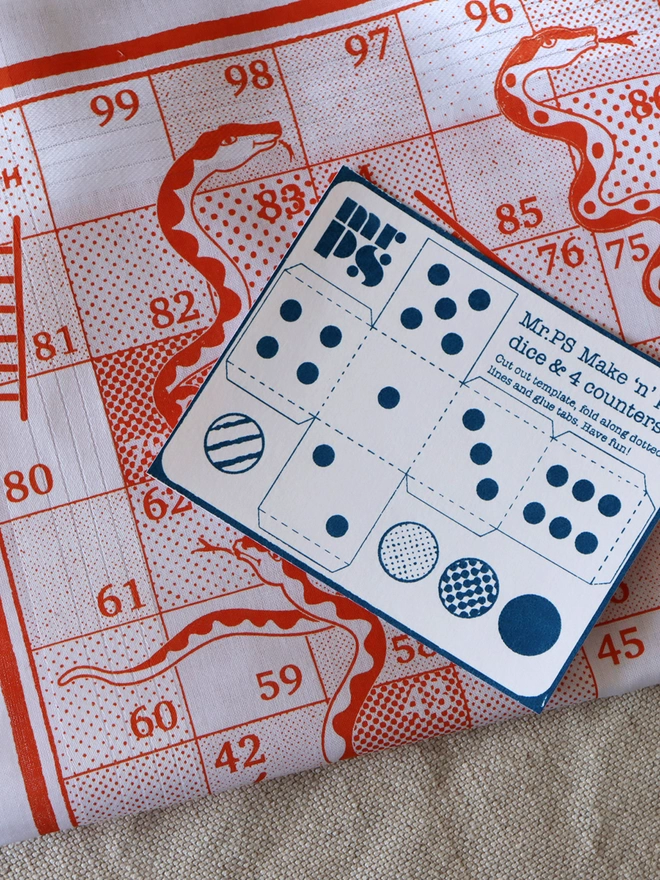 detail of an orange Mr.PS Snakes & Ladders hankie with a blue card