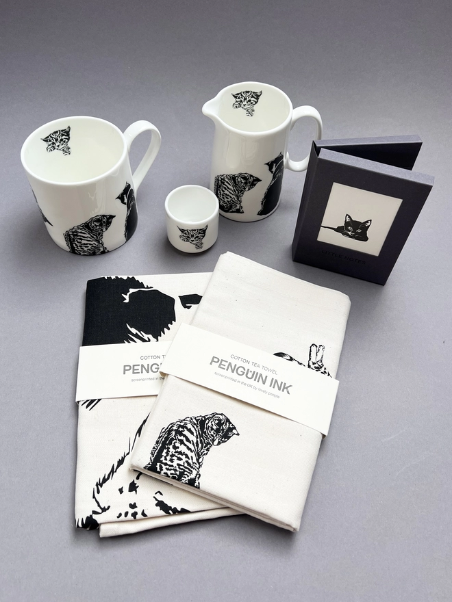 Collection of matching cat tea towels, mugs and jugs
