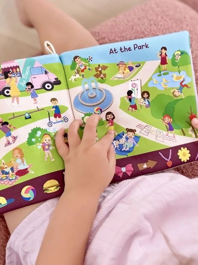Can you find Teddy Search and find soft book open on a page showcasing a park scene
