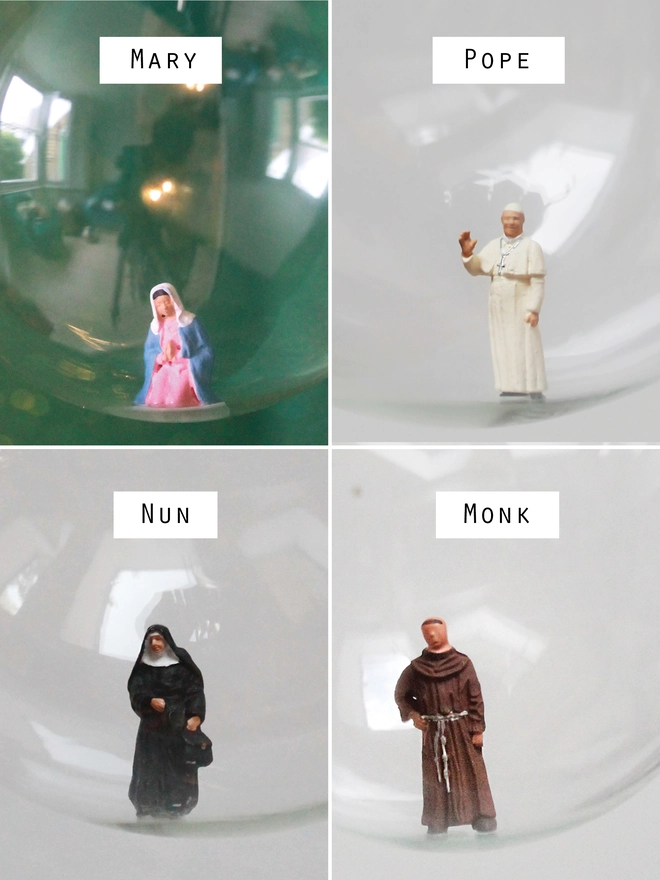 Miniature figures of Virgin Mary, the Pope, a nun and a monk in Christmas bauble