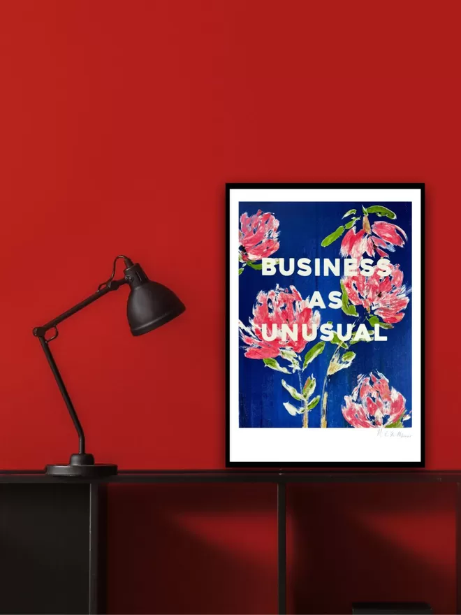 BUSINESS AS UNUSUAL fine art print based on an original monoprint by M.E. Ster-Molnar.  Shown against a red wall with a black shelf and black lamp.  