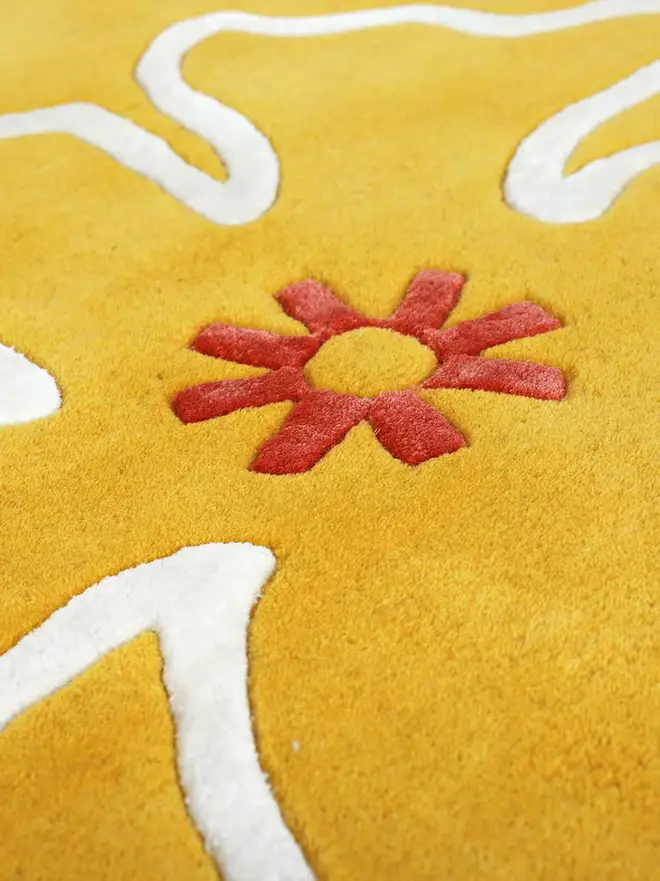 Hibiscus Hand Tufted Rug, a colourful rug on a plain surface. 