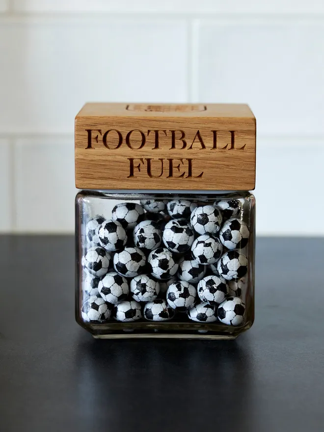 'Football Nuts' Oak Jar. A glass jar with an oak lid engraved with football nuts and the three lions crest, filled with sweets.