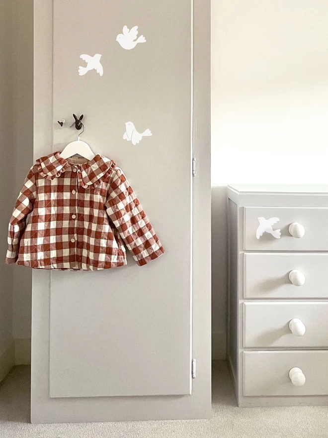 White bird wall stickers on wardrobe in girls nursery bedroom
