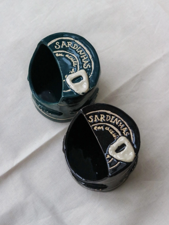 Sardine Can Salt Pig, a pair of salt pigs on a white tablecloth. 