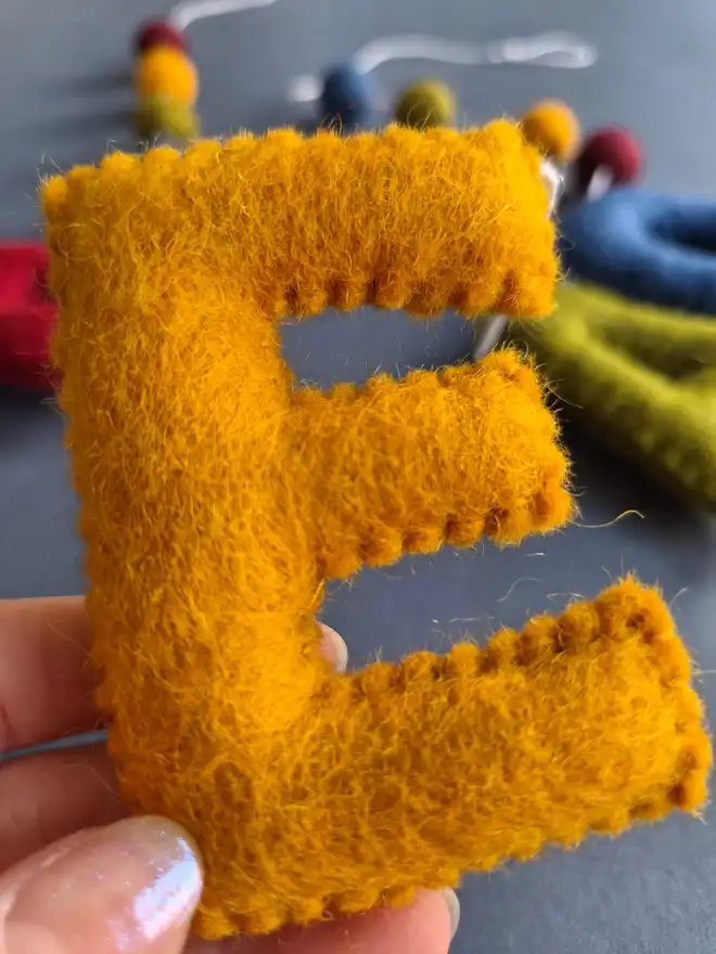 Felt hand stitched letters featuring the word 'Happy Birthday' in gorgeous rich tones