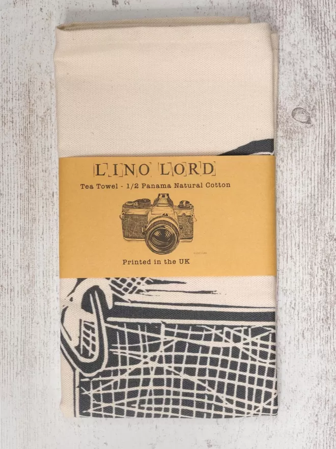 Picture of a tea towel with an image of a Camera, taken from an original lino print