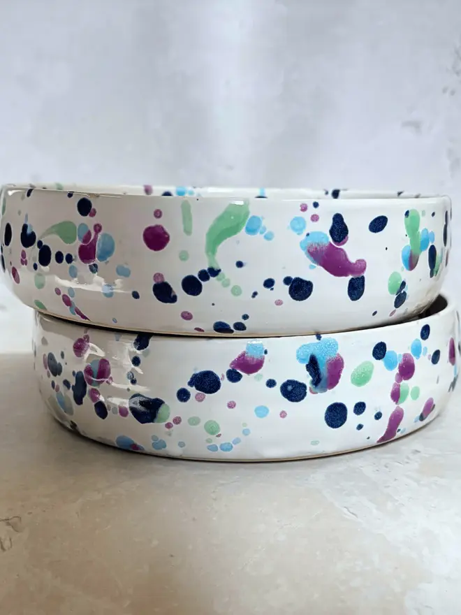 Sweetpea Pasta Bowl, a pair of colourful bowls stacked together on a stone surface. 