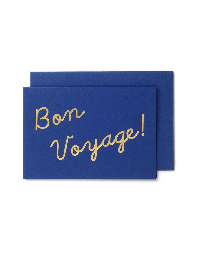 An elegant navy greeting card that says 'Bon Voyage!', wth an envelope that has a gold seal