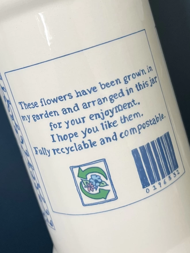 A close-up of the humorous illustrated jar label which wraps around handmade Garden Flowers vase.